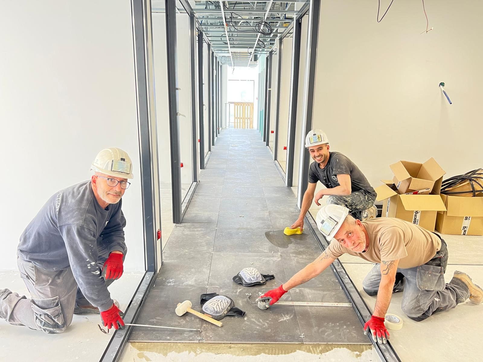 Équipe Pégase posant du carrelage grand format sur un chantier
